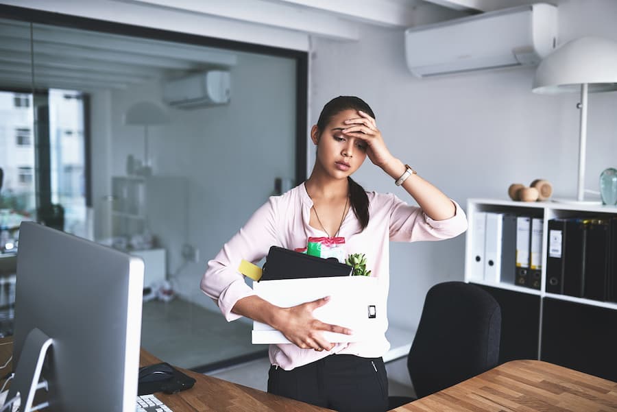 A stressed-out woman removes items from a workstation